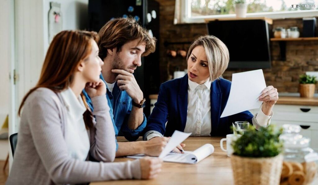 a woman having a professional discussion with a couple.