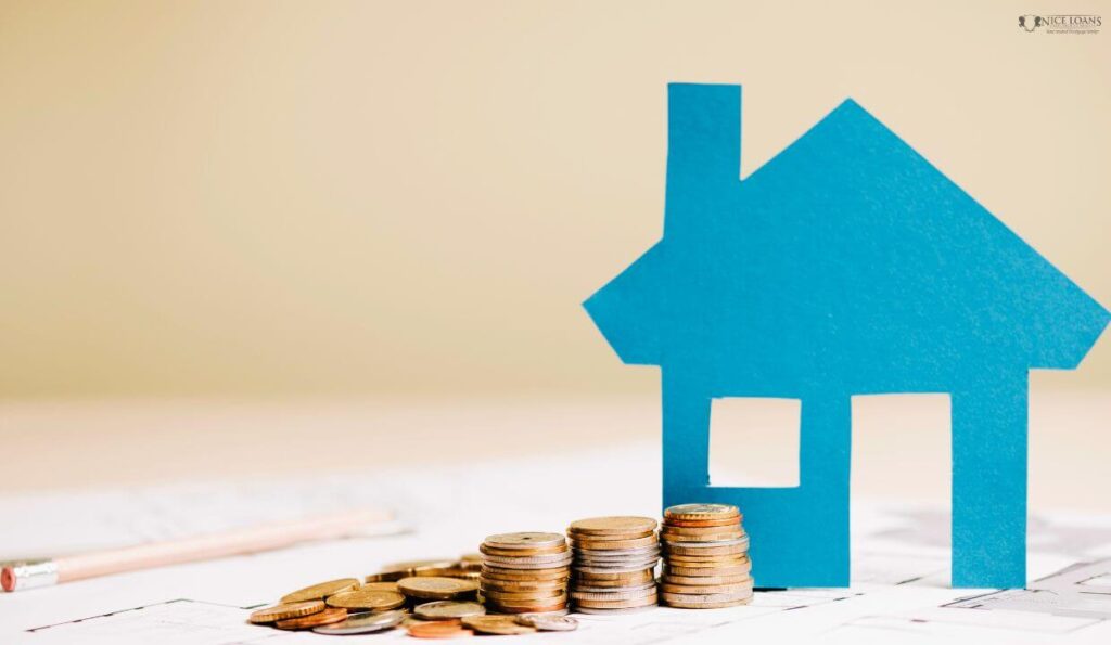 a blue model home beside a stack of coins.