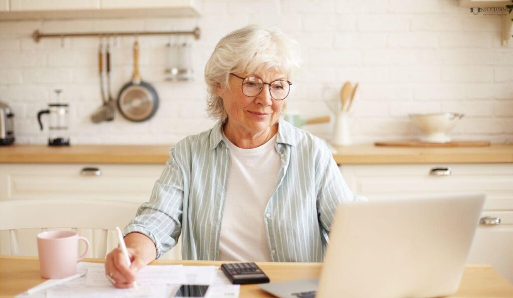 an old woman at her table doing calculations. 