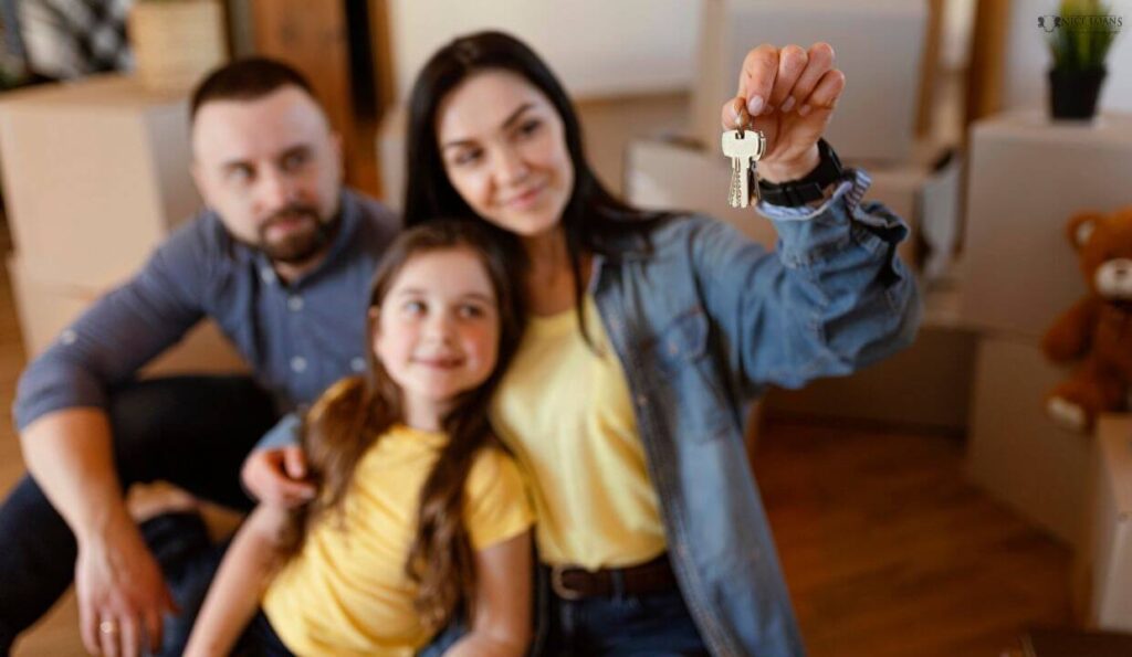 A family of three with the woman holding the keys to their new home!