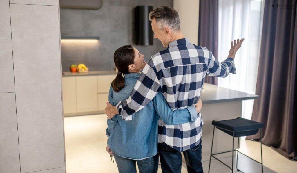 backside shot of a couple hugging in their new home.
