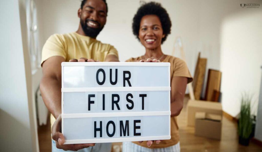 a couple holding a board with our first home written on it.