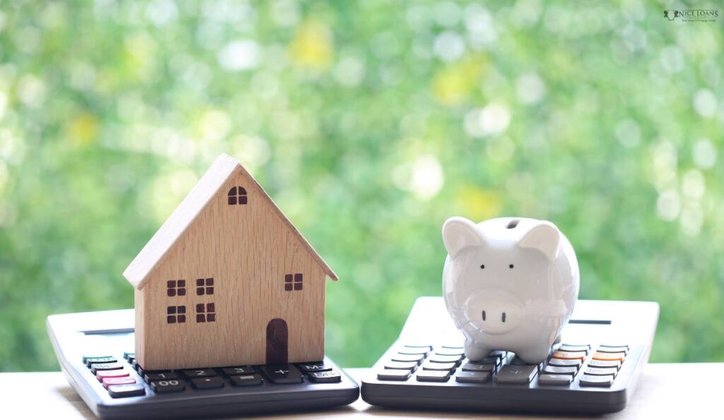 A wooden house and a piggy bank on top of two calculators respectively.