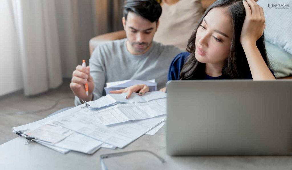 a couple discussing their finances with their bills and laptop on the table